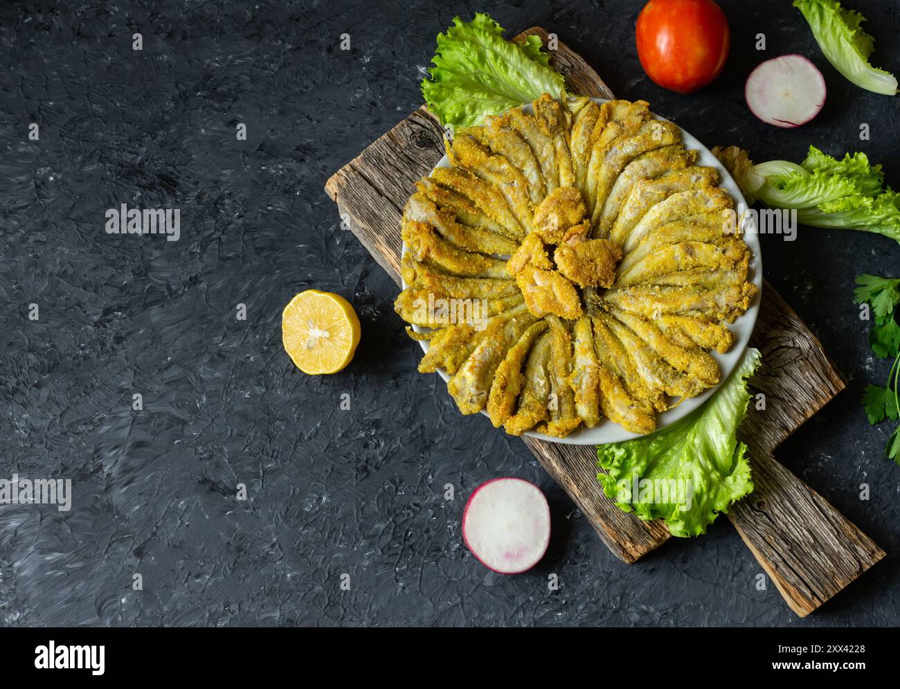 Cooked haddock fishes with cornflour in plate on rustic table Stock Photo