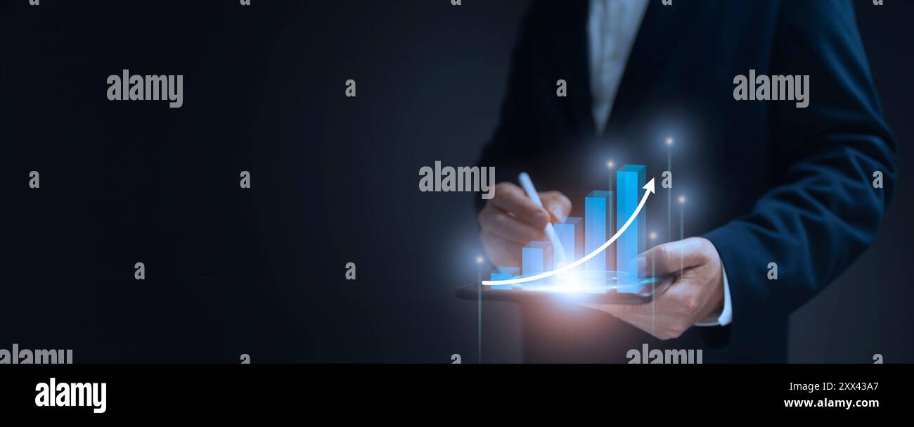 A businessman holds a tablet displaying a glowing bar graph with an ...