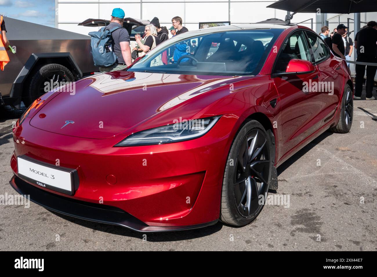 British Motor Show 2024, held at Farnborough, Hampshire, England, UK, from 15 - 18 August 2024. Day 2 of the annual event at Farnborough International Exhibition Centre. A red Tesla Model 3 electric car on display. Stock Photo