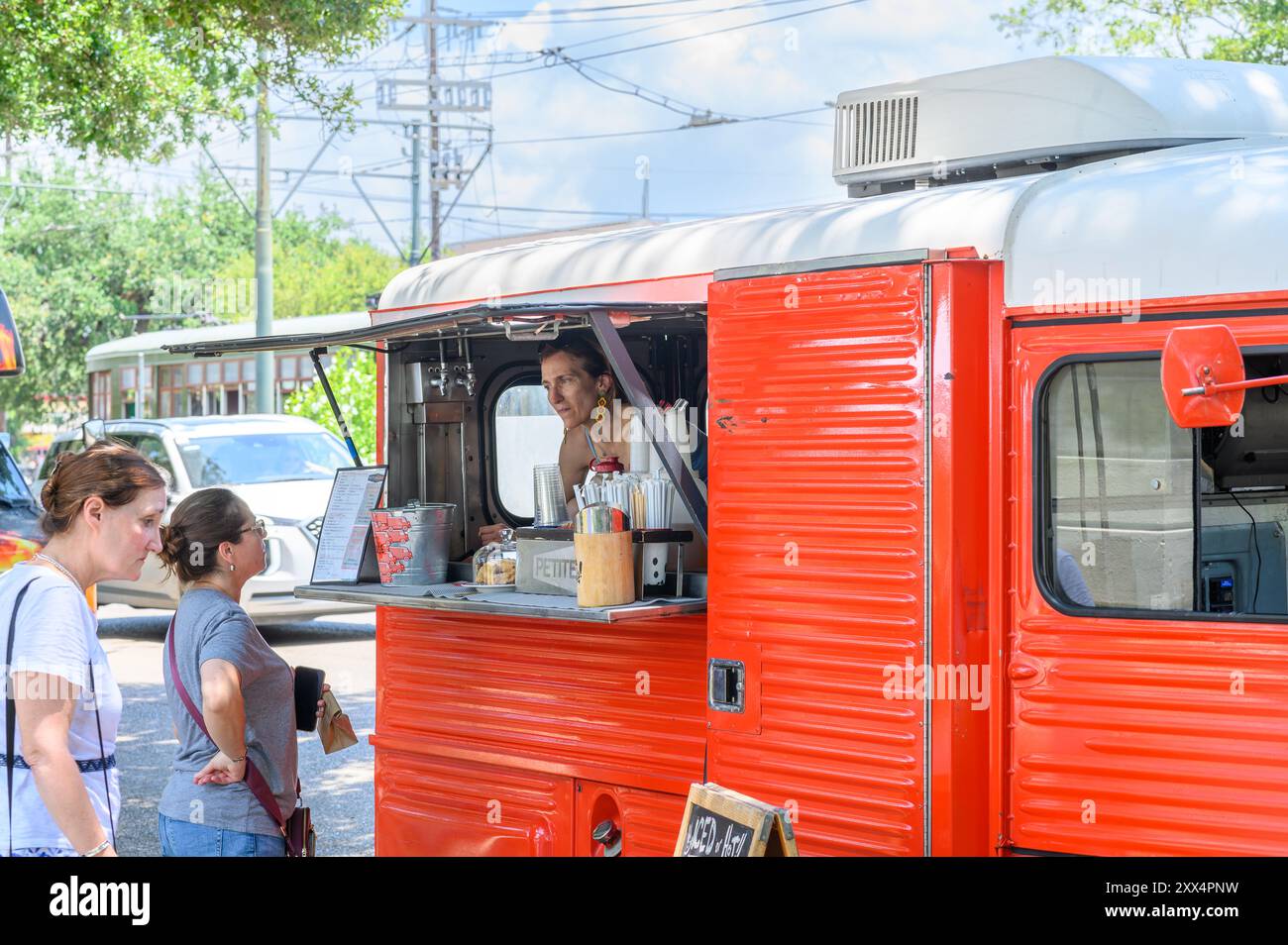 NEW ORLEANS, LA, USA - MAY 25, 2024: Closeup of customers and vendor in mobile coffee shop parked on Carrollton Avenue in Uptown Neighborhood Stock Photo