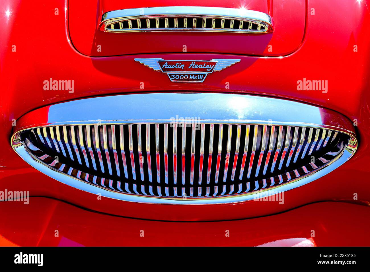 Chrome radiator grille and air intake on a 1964 Austin Healey 3000 Mk3 polished to perfection as it basks in the sun at a classic car show. Stock Photo