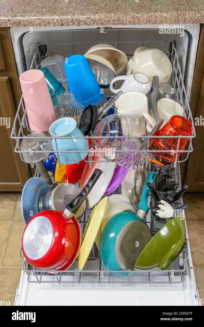 Vertical close-up shot of colorful dishes loaded in a dishwasher. Stock Photo