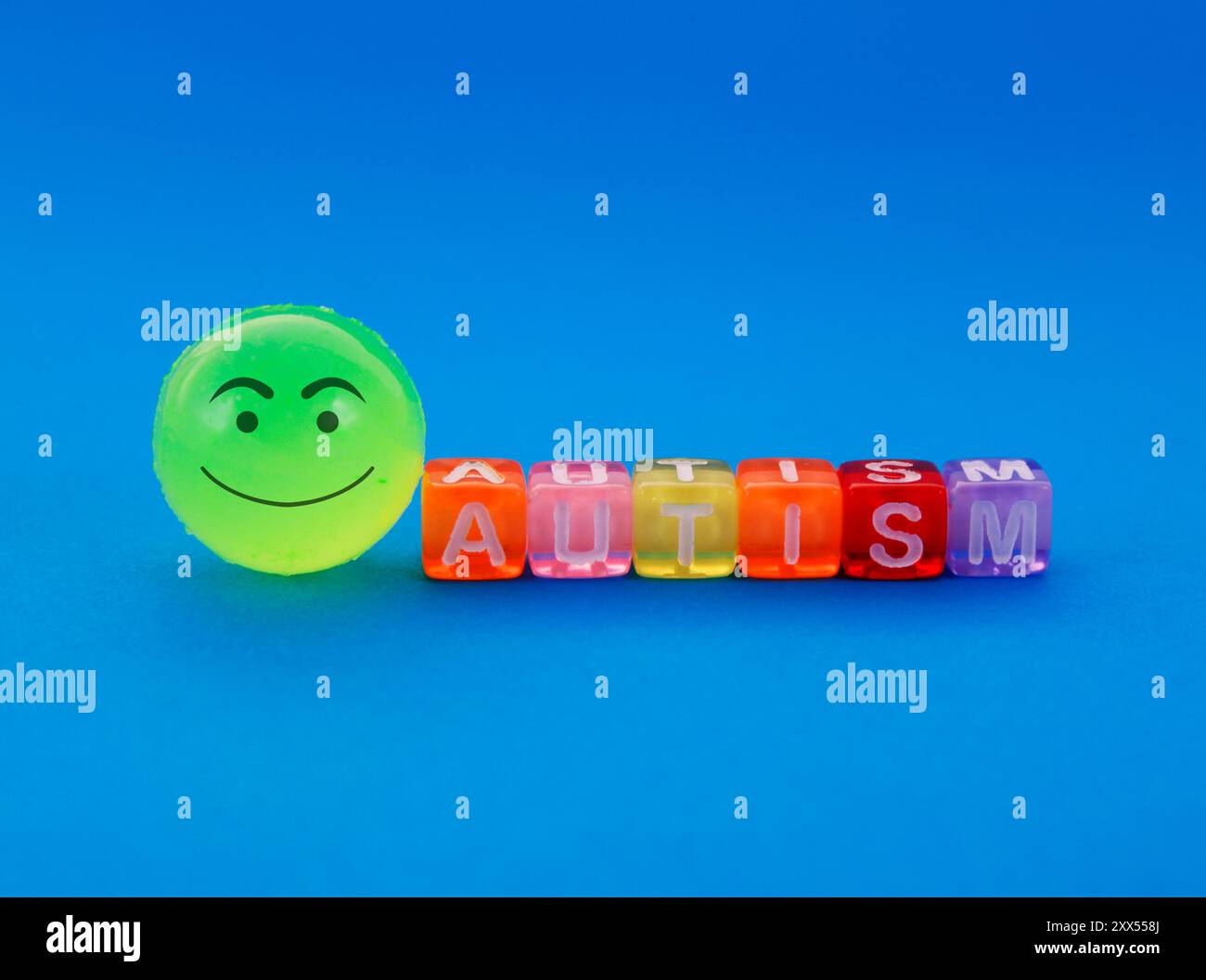 Autism, sphere with happy face next to colorful cubes Stock Photo