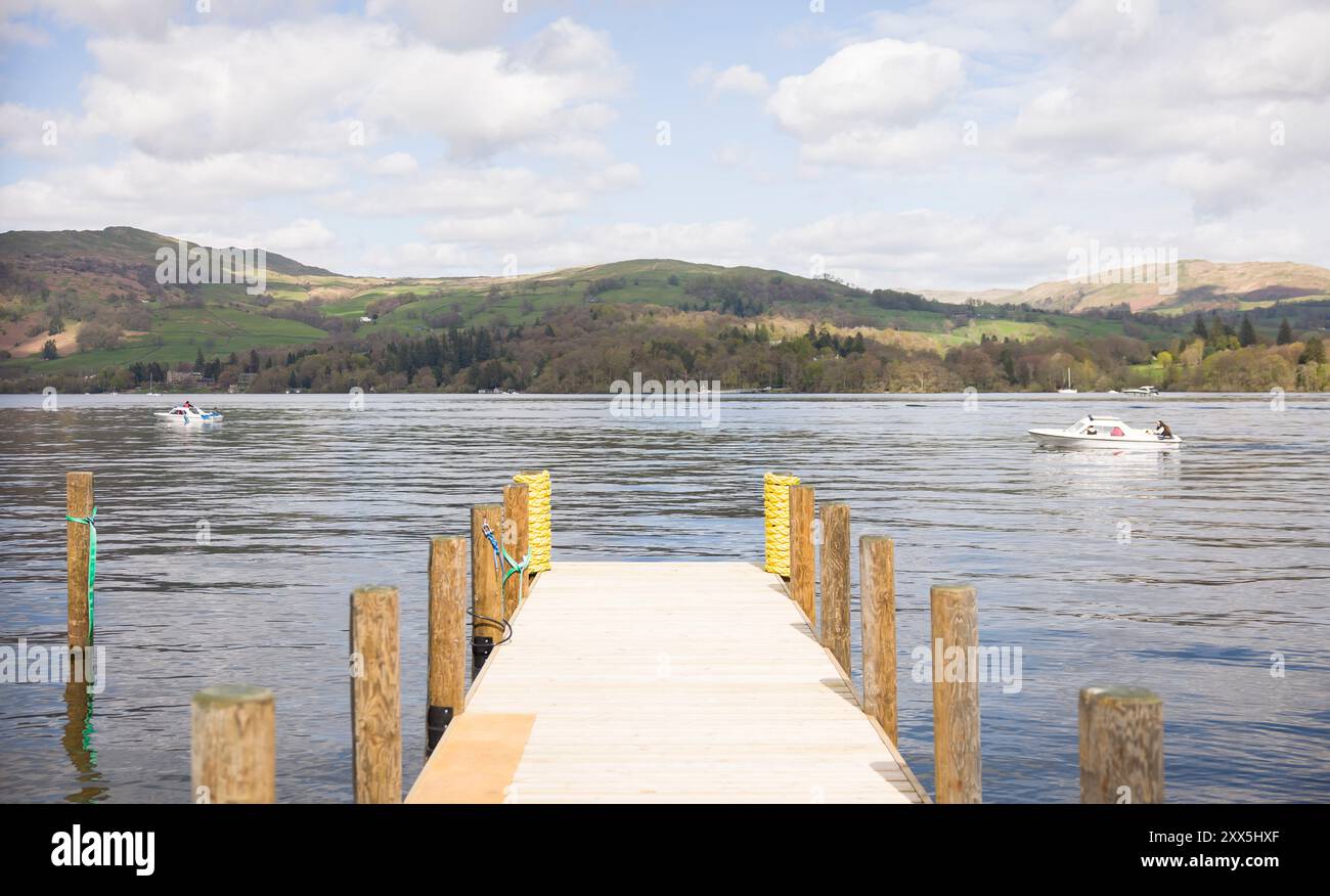 Lake Windermere with wooden jetty and boats on a sunny day in Lake District, Cumbria, UK Stock Photo