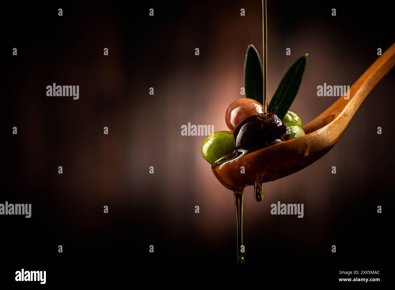 Dop olive oil poured into spoon Stock Photo - Alamy
