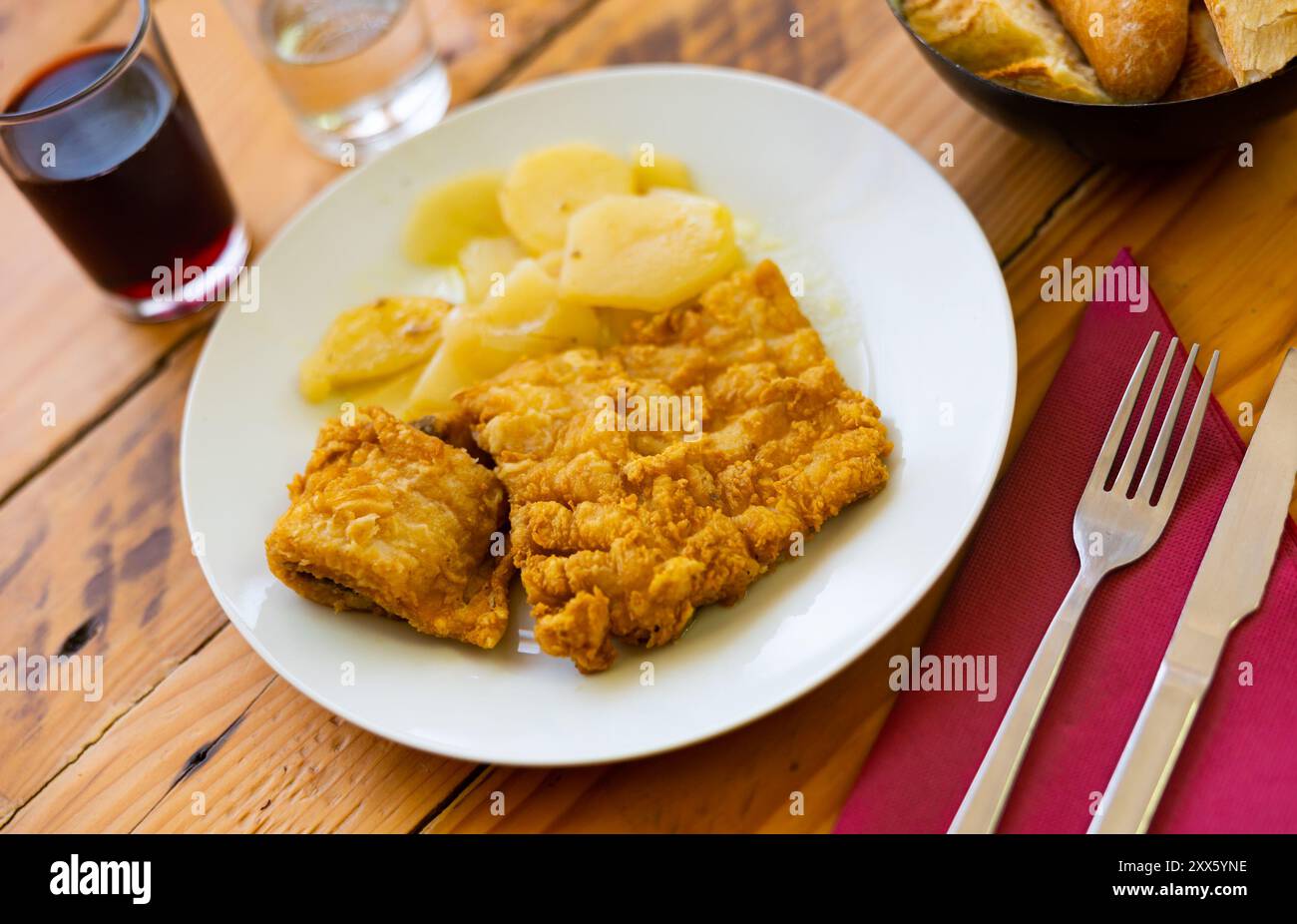 Crispy breaded cod fillet with sliced potatoes for dinner Stock Photo ...