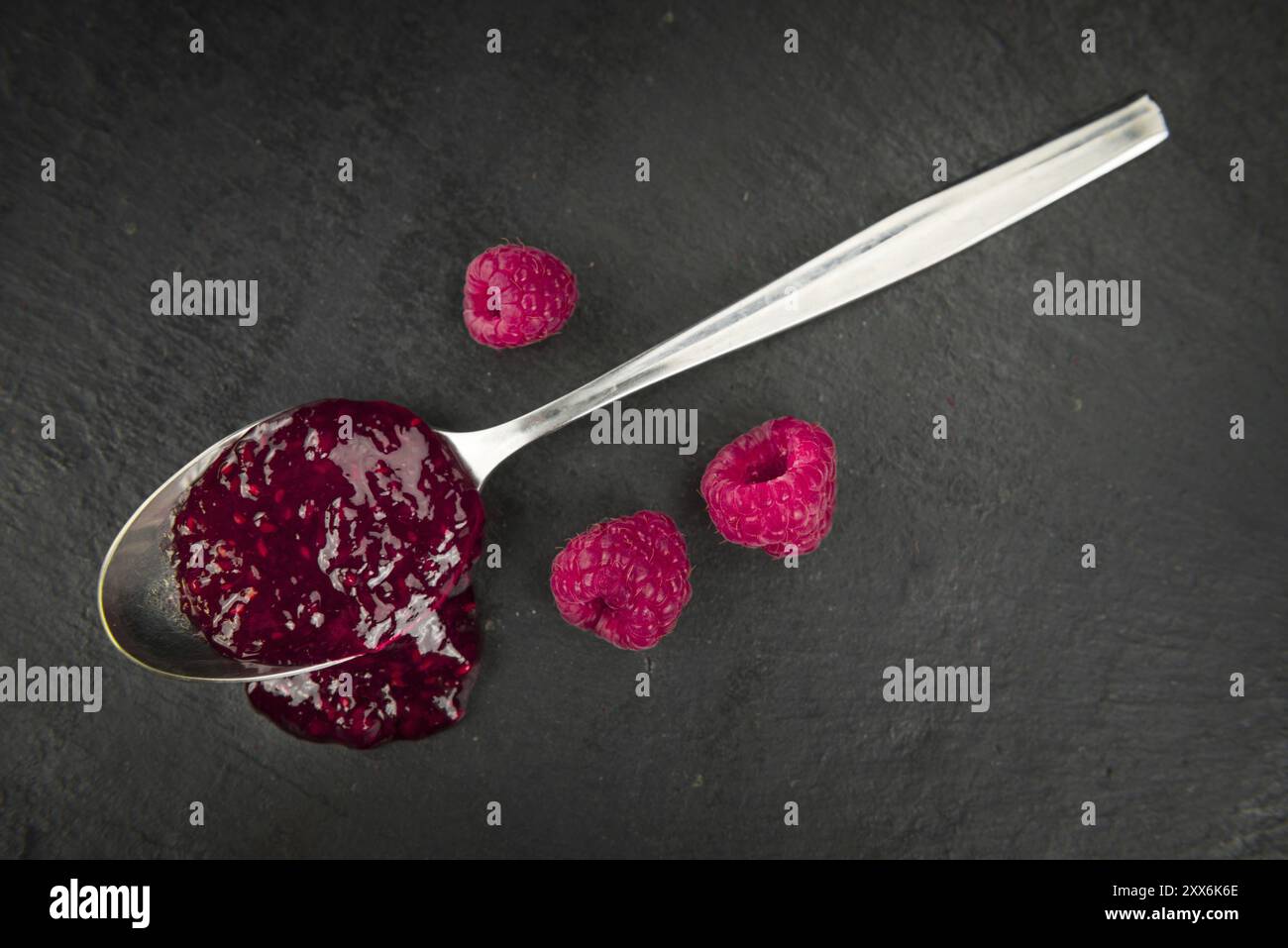 Some Raspberry Jam on a slate slab as detailed close-up shot, selective ...