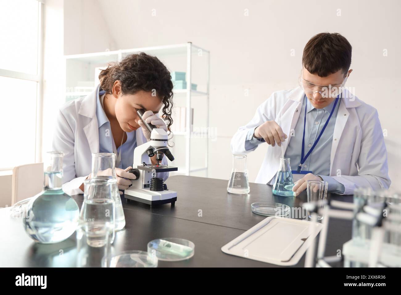 Microchemists Young chemists with microscope working in laboratory Stock Photo - Alamy