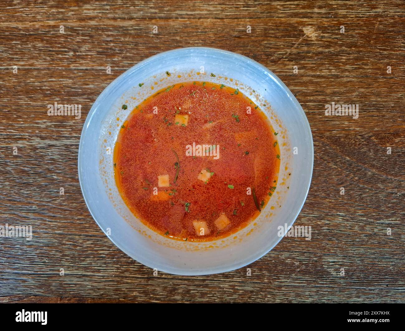 Tomato soup on white boul and wood table background Stock Photo
