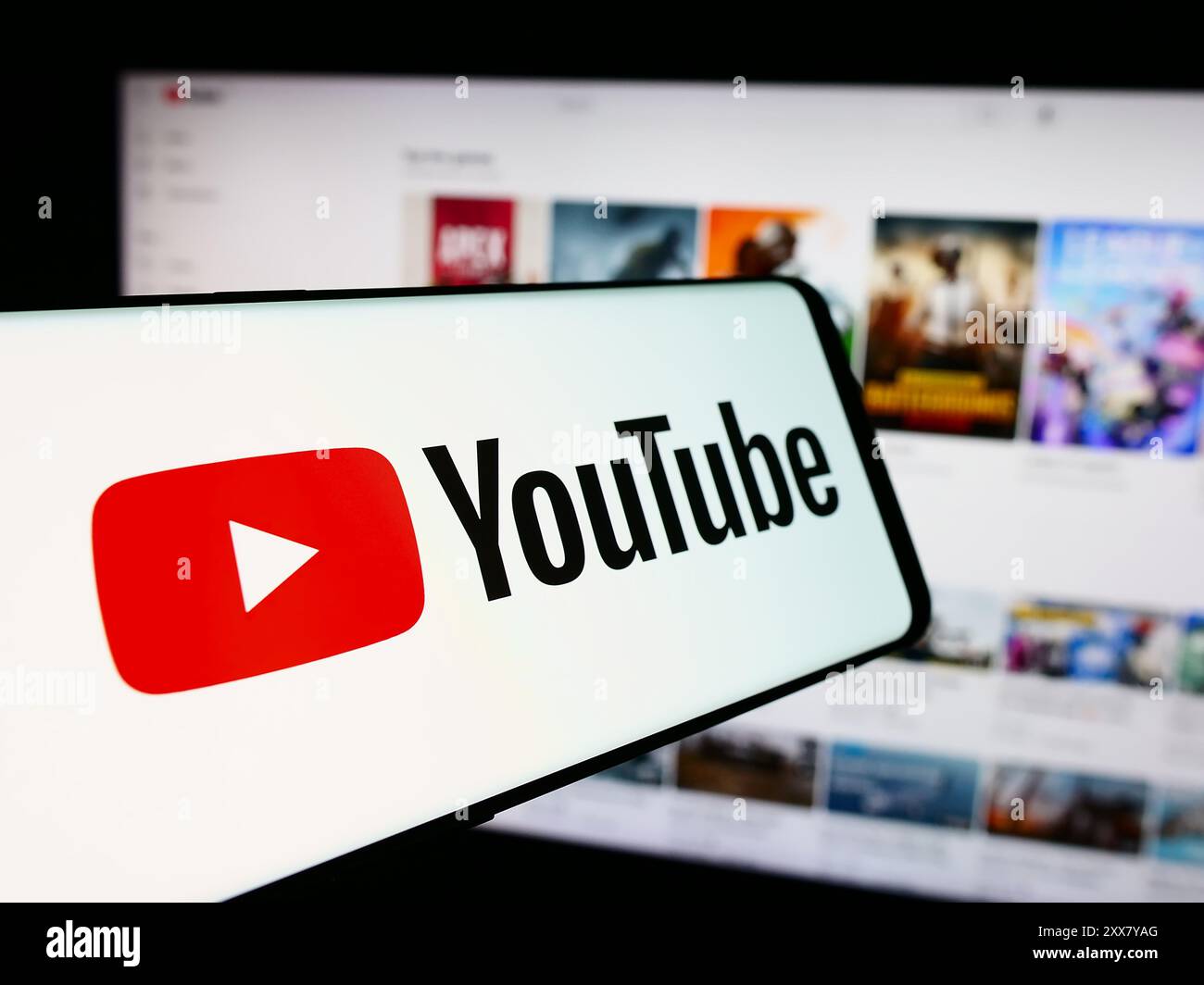 Cellphone with logo of American online video sharing platform company YouTube in front of website. Focus on center-left of phone display. Stock Photo