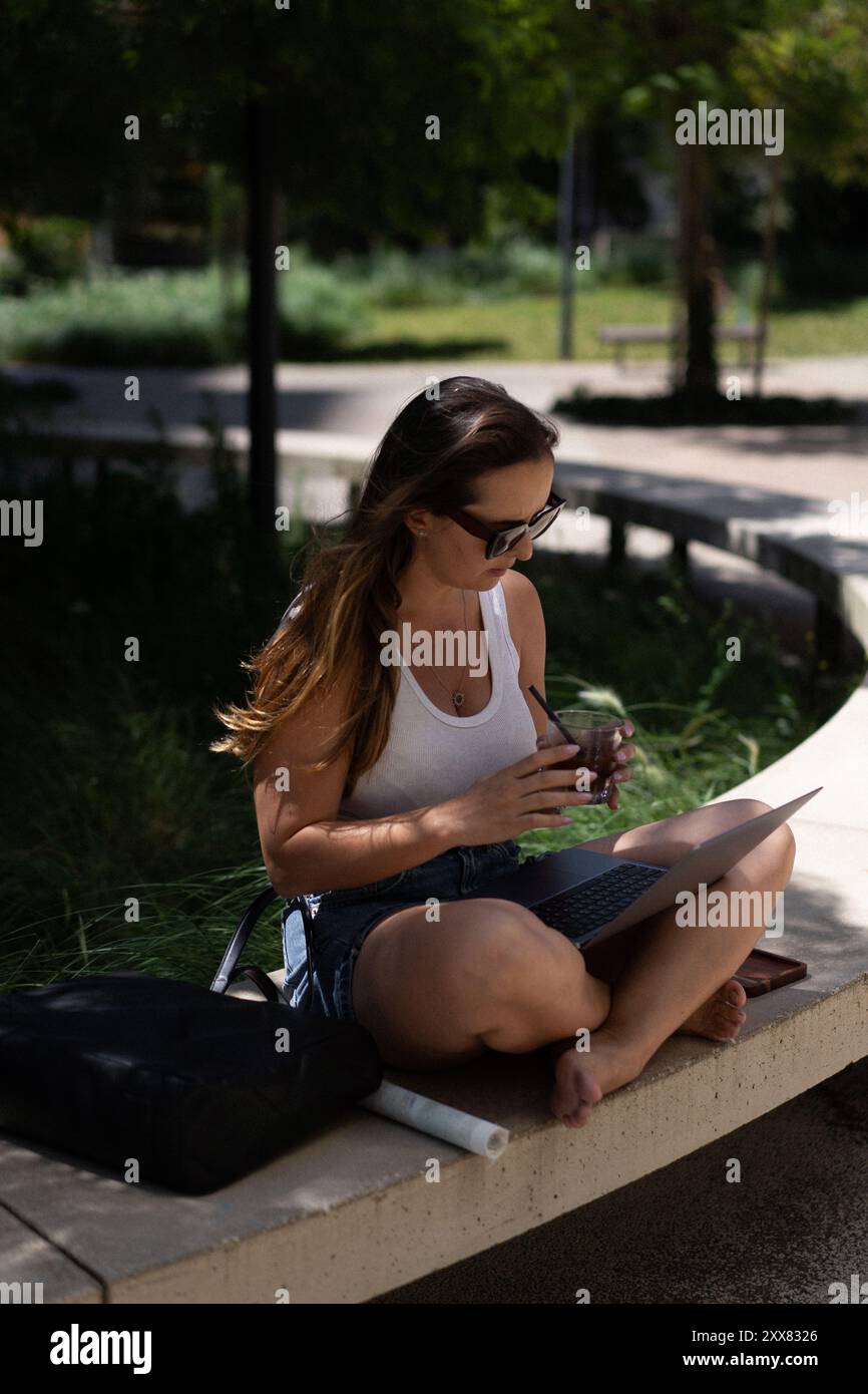 Woman working on laptop outside. Stock Photo