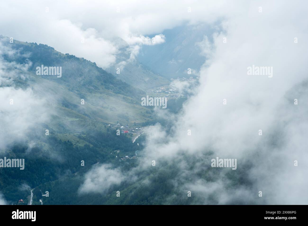 aerial view through the clouds to valley with mountain villages Stock ...