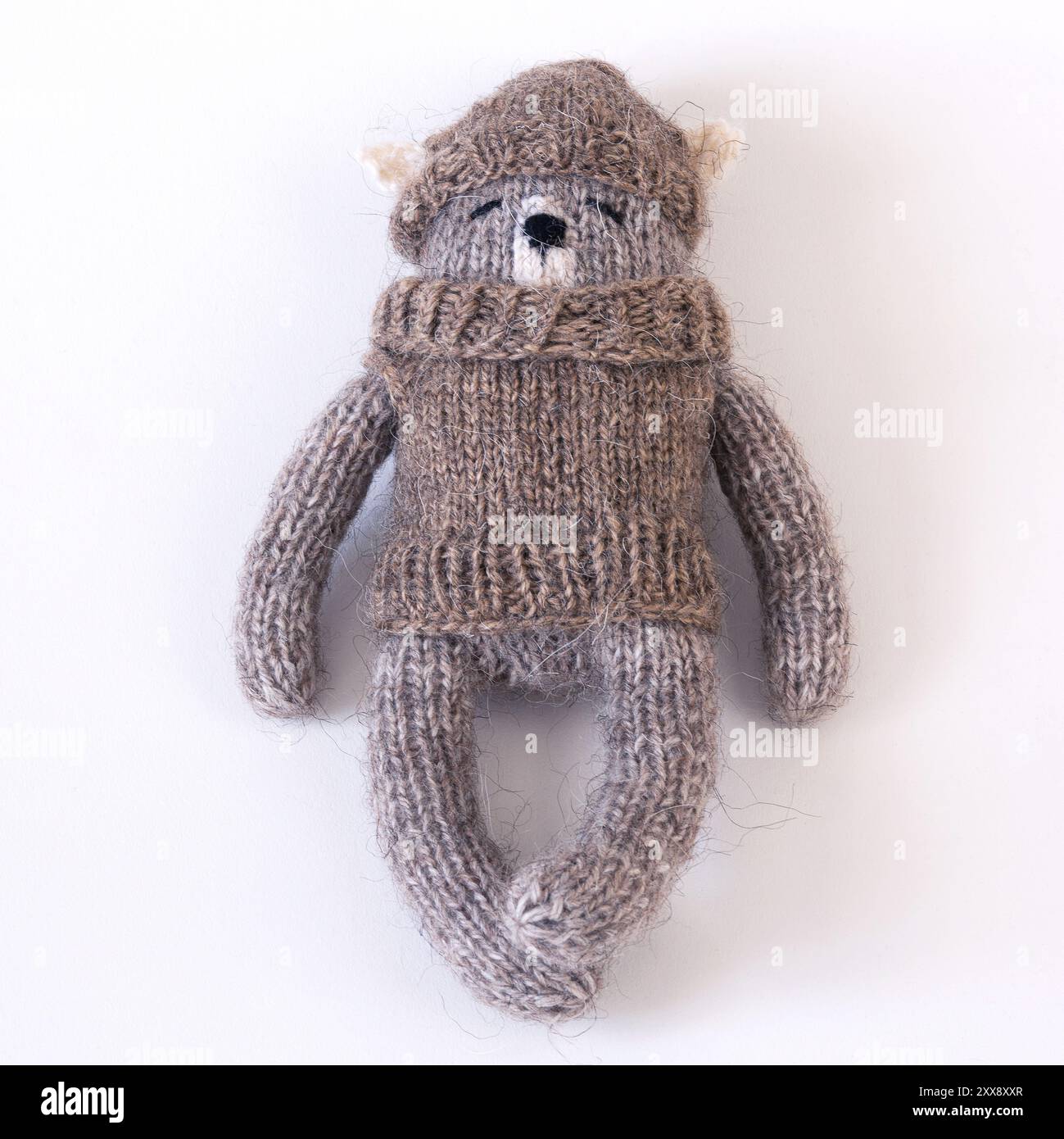 Knitted woolen bear in a sweater and hat on a white background Stock ...