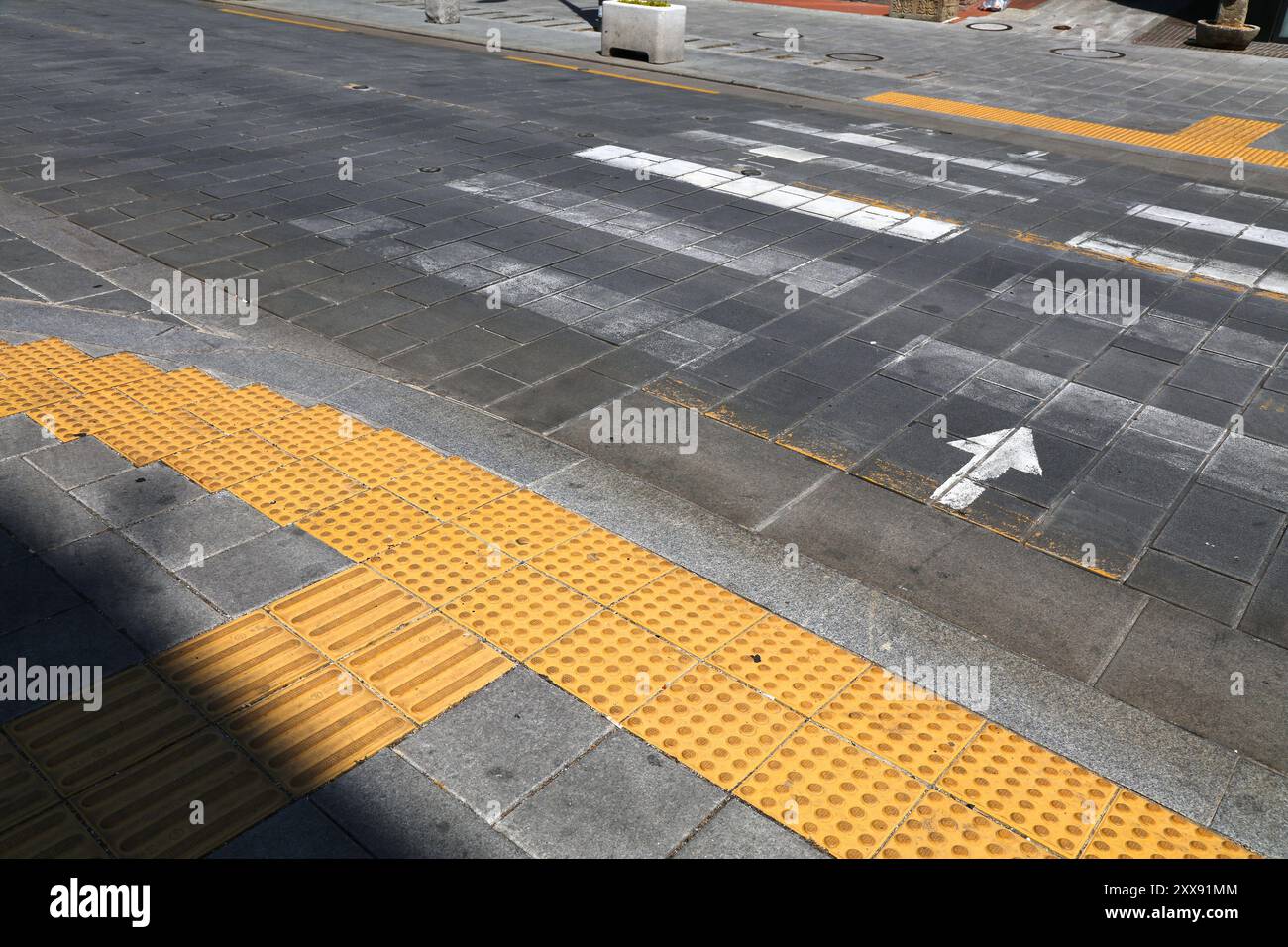 Tactile paving (tenji blocks) by the pedestrian crossing in Seoul, South Korea. Vision impaired disability infrastructure. Stock Photo