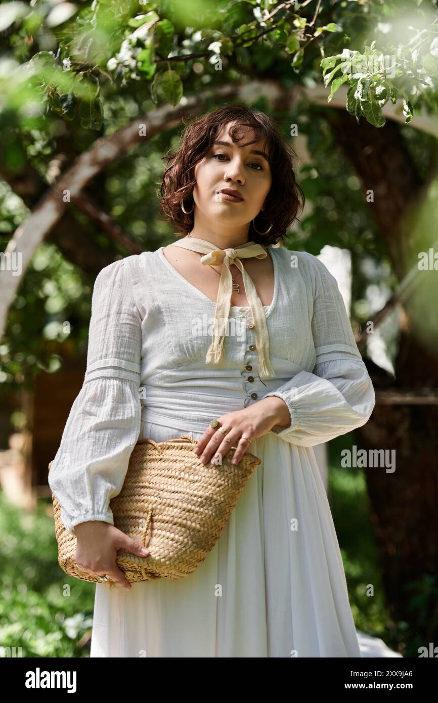A young woman in a white dress and straw hat enjoys a summer day in a ...