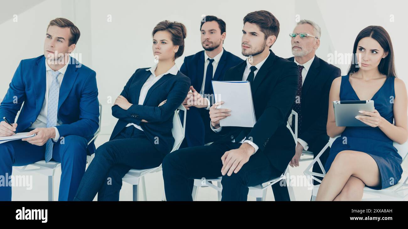 Confident young managers making notes during lecture Stock Photo
