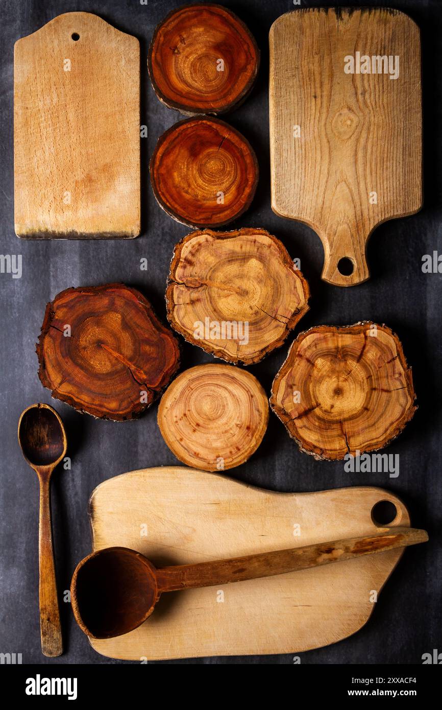 Old wooden cutting boards, tree trunk slices and kitchen utensils on ...