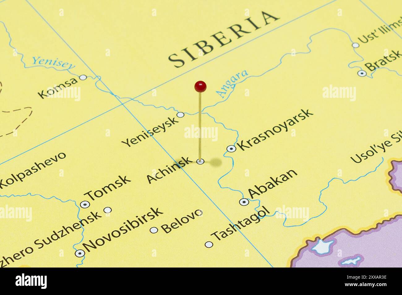 Close up to a Achinsk city with a red pin needle into Russia country ...