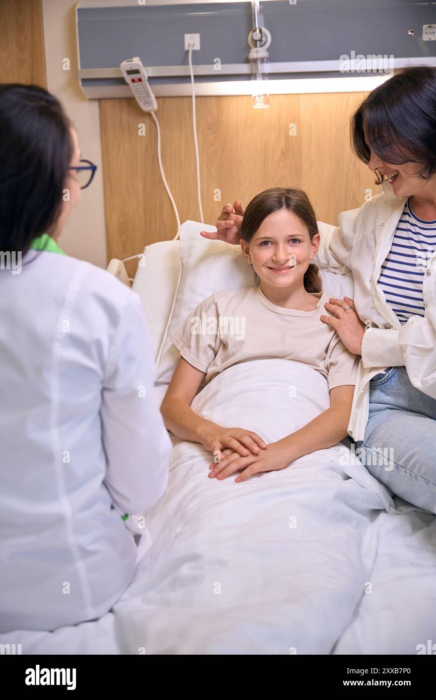 Caring mother gently hugs her sick daughter Stock Photo - Alamy