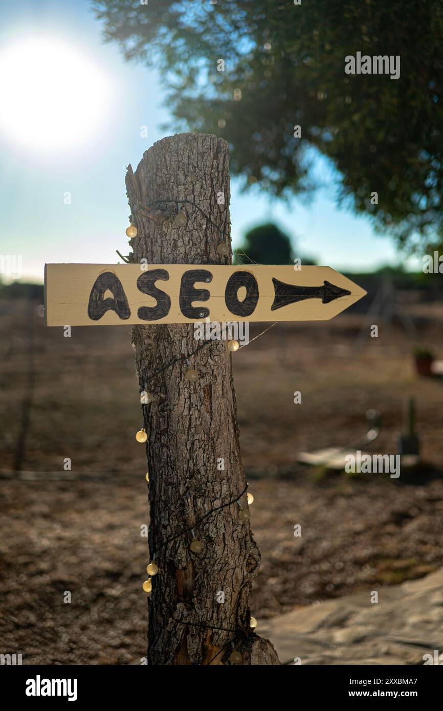 Spanish Sign Posts Wooden sign indicating the direction to the bathroom in Spanish in a ...