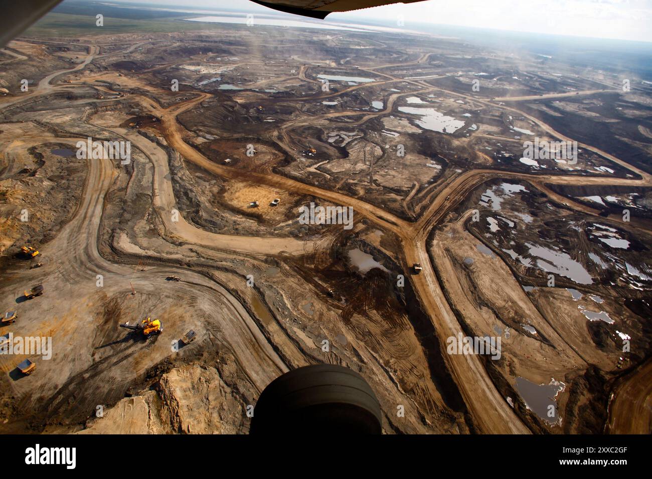 Excavation of oil sand at one of the oil sand mines in Fort McMurray in Alberta, Canada. The Athabasca oil sands deposit is among the largest in the world.  The bitumen, also commonly named tar (hence tar sands), contains lots of hydrocarbons, but is notoriously hard to extract. For every 100 BTU of energy extracted, 70 BTU is lost in the process. In 2011 alone, the oil sands operations in Canada produced 55 million tons of ‘greenhouse gas emissions’. That’s eight percent of Canada’s total emissions. Stock Photo