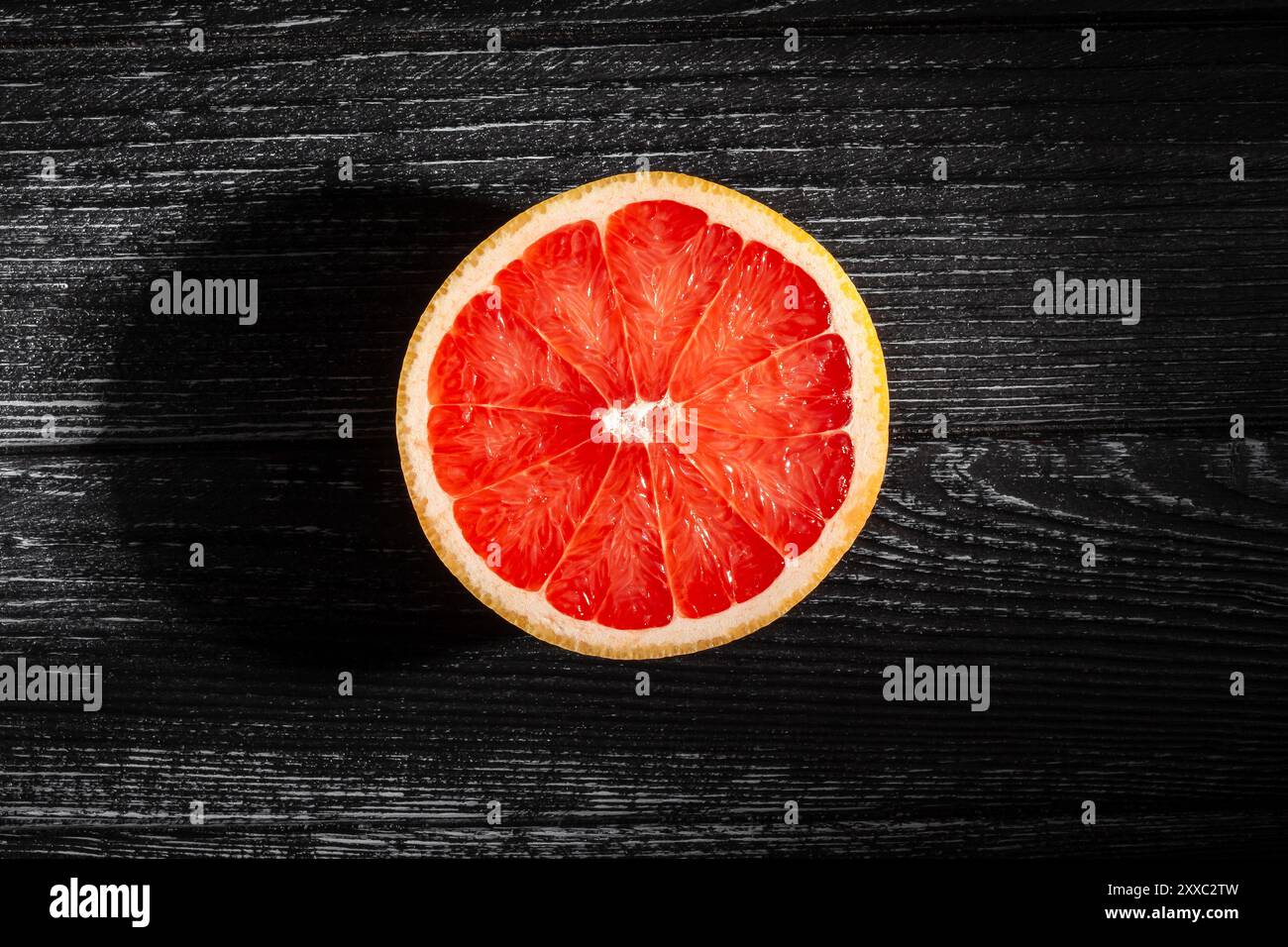 sliced grapefruit on black wood background top view Stock Photo