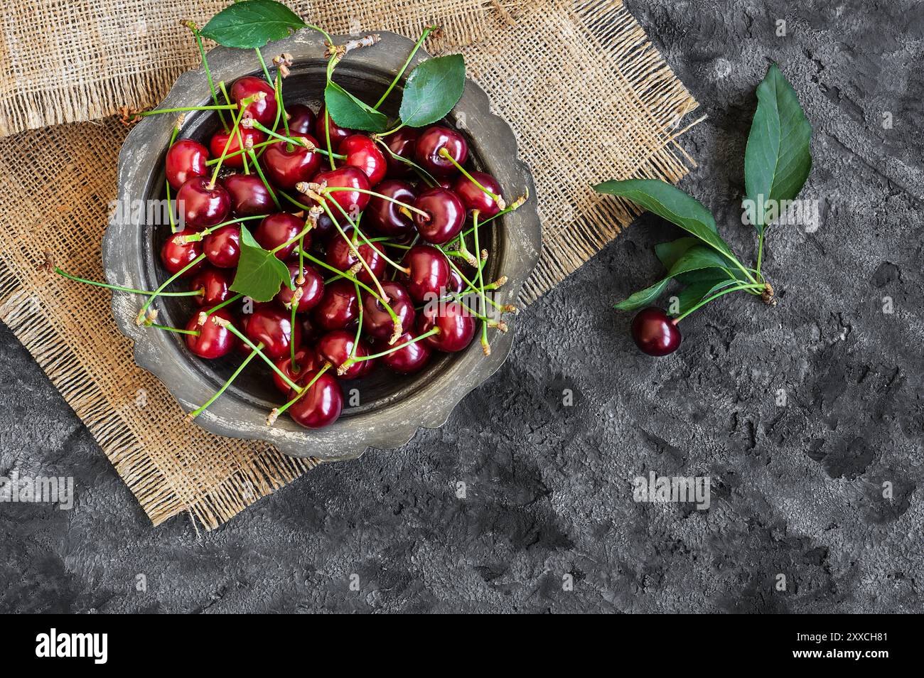 Fresh ripe sour cherry fruits in bowl on rustic table, red summer fruits Stock Photo