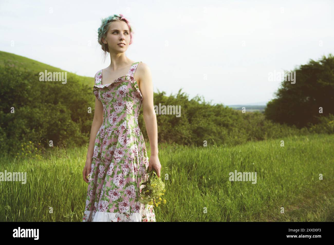 Young happy smiling girl in a calico dress with a bouquet is walking along a country road with green grass Stock Photo - Alamy Young happy smiling girl in a calico dress with a bouquet is walking along a country road with green grass Stock Photo - Alamy