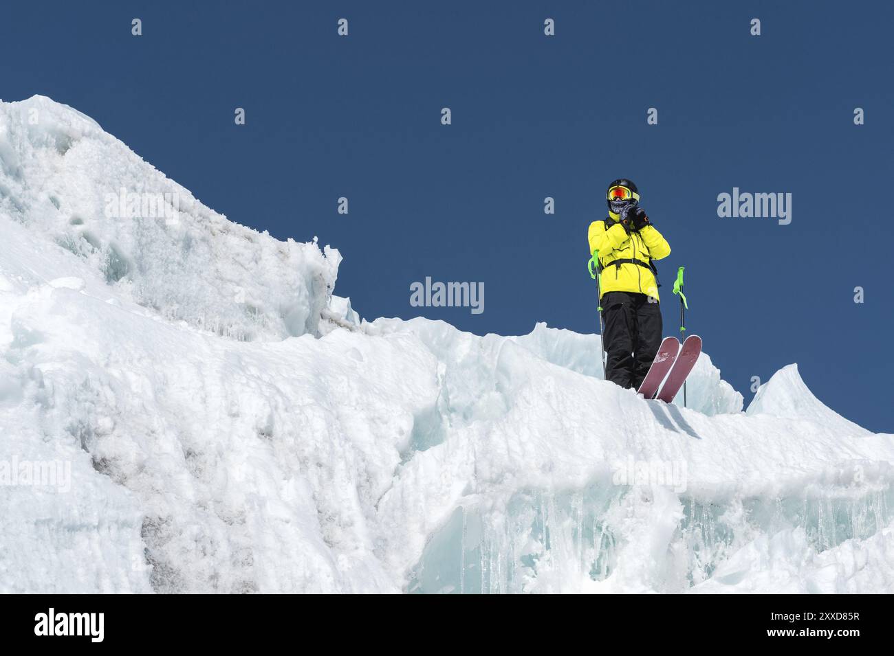 A freerider skier in complete outfit stands on a glacier in the North Caucasus. Skier preparing before jumping from the glacier Stock Photo