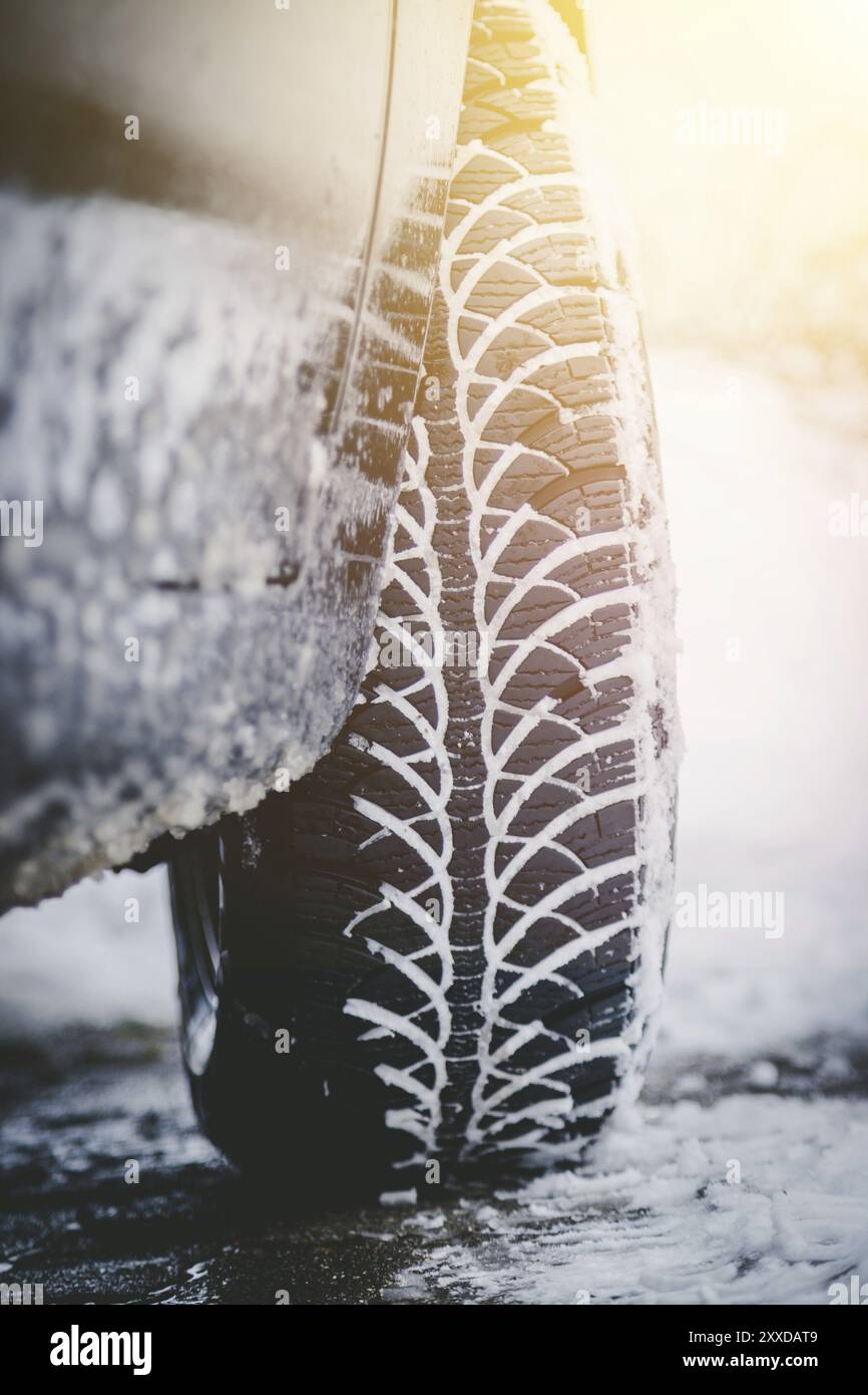 Close up of car tire covered with snow on a slippery road Stock Photo