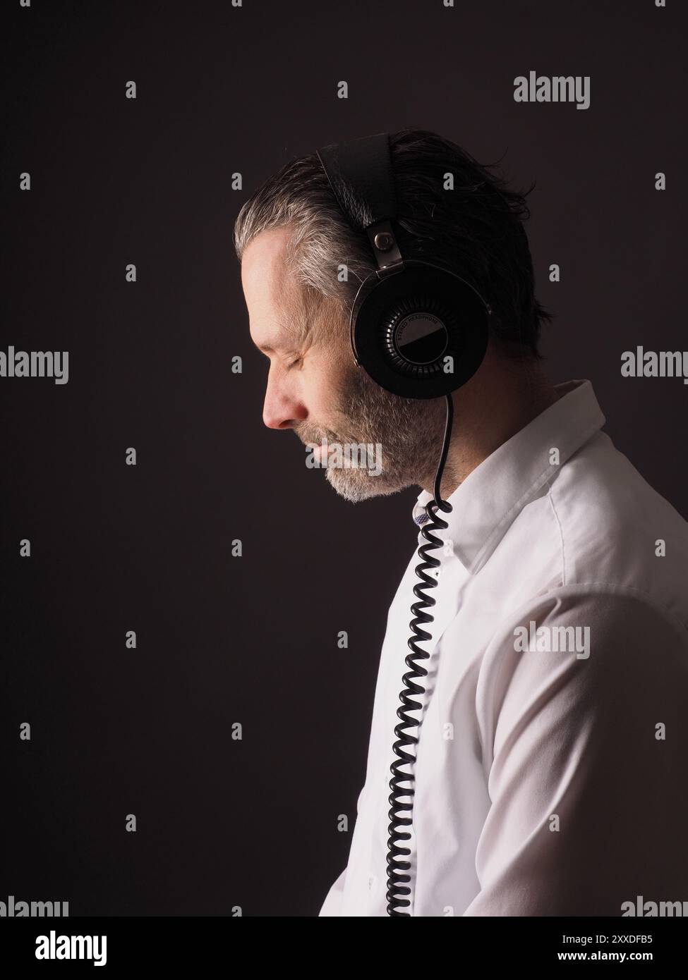 Handsome man with vintage studio headphones on a dark background Stock Photo
