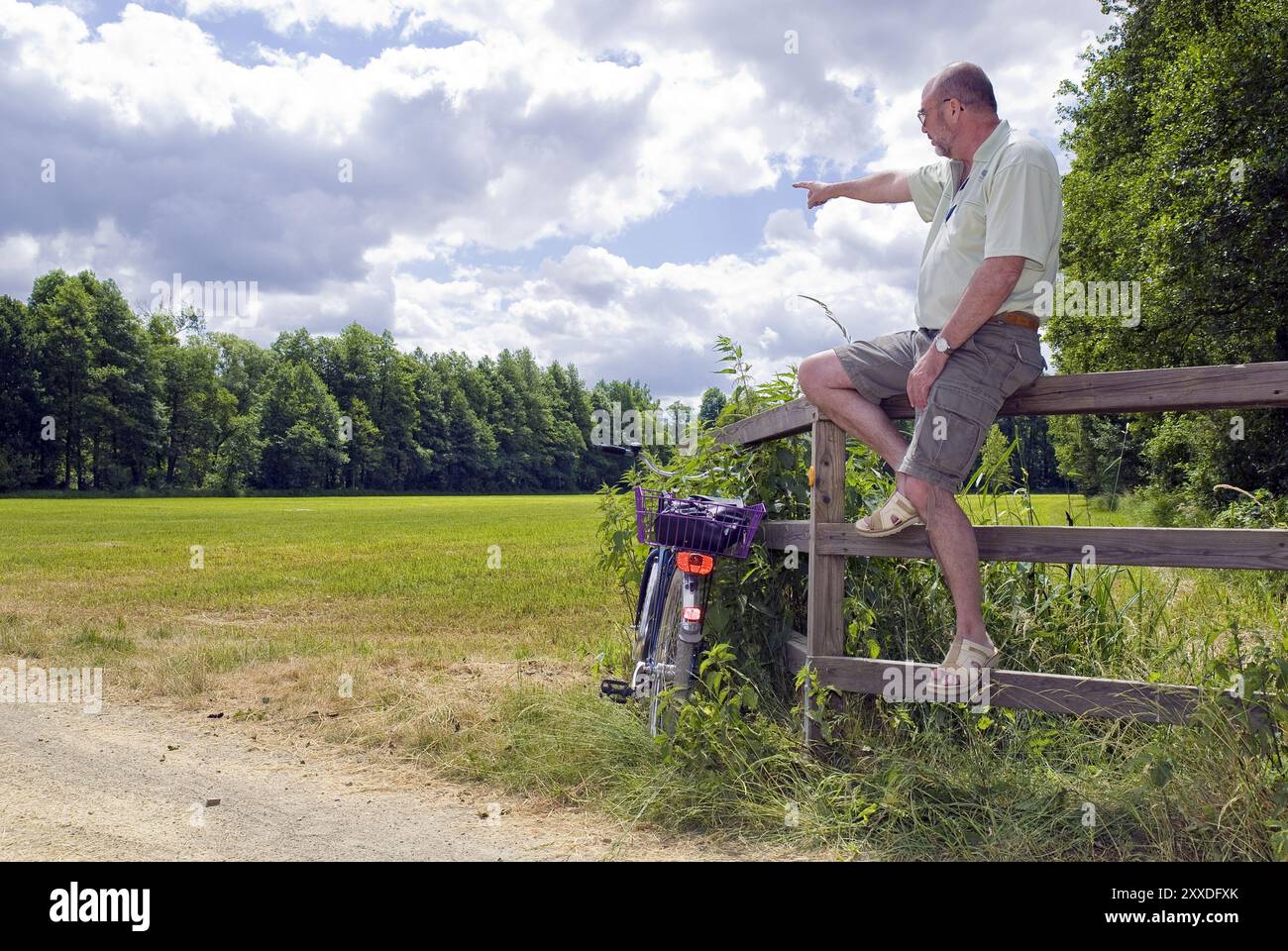 Man sitting on a railing Stock Photo - Alamy