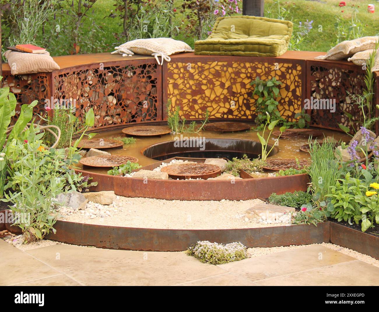 A Metal Framed Modern Garden Seating Area with Pond. Stock Photo