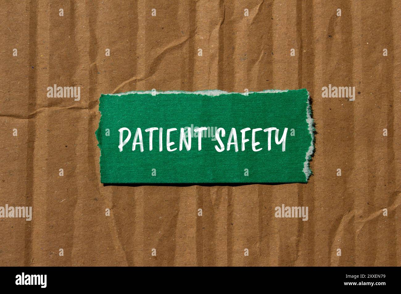 Patient safety message written on ripped torn green paper piece with ...