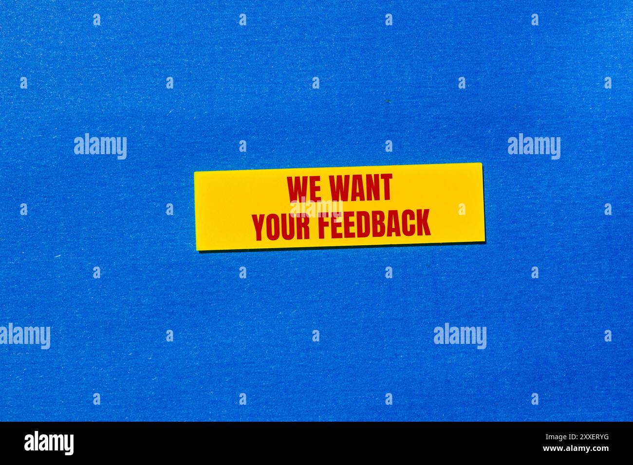 We want your feedback message written on yellow sticker with blue background. Conceptual we want your feedback symbol. Copy space. Stock Photo