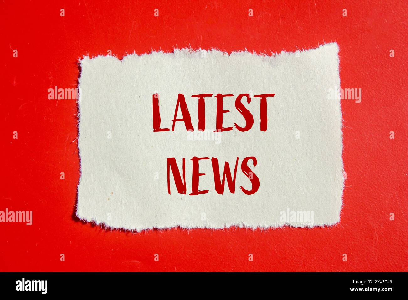 Latest news message written on ripped torn paper piece with red ...
