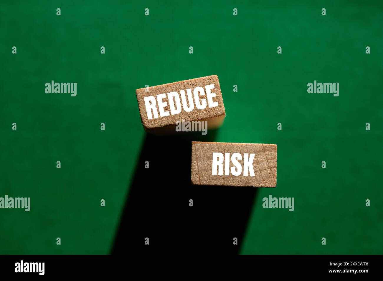 Reduce risk message written on wooden blocks on green background ...