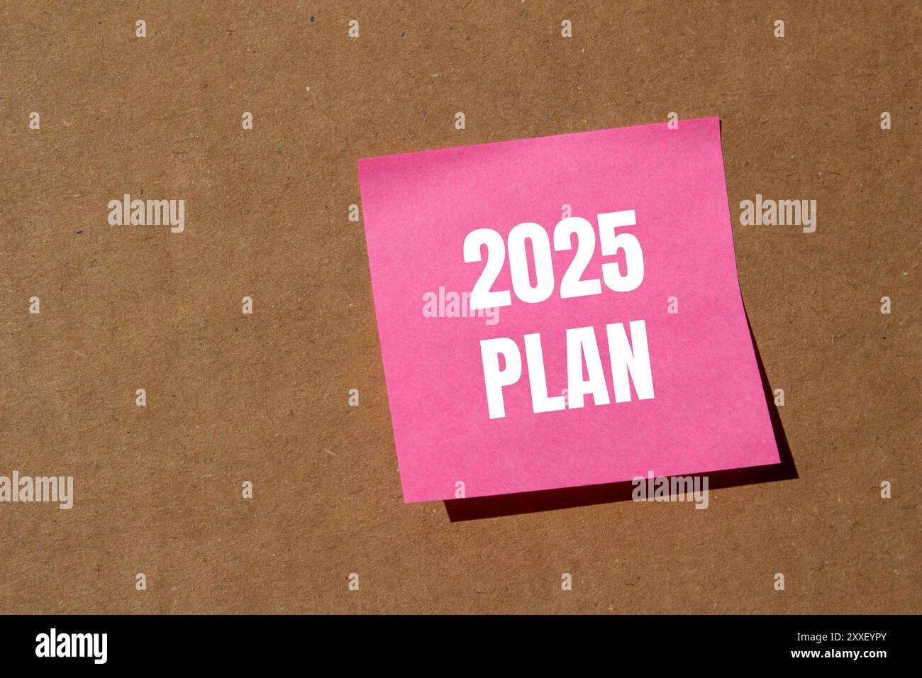 2025 plan message written on pink paper with cardboard background