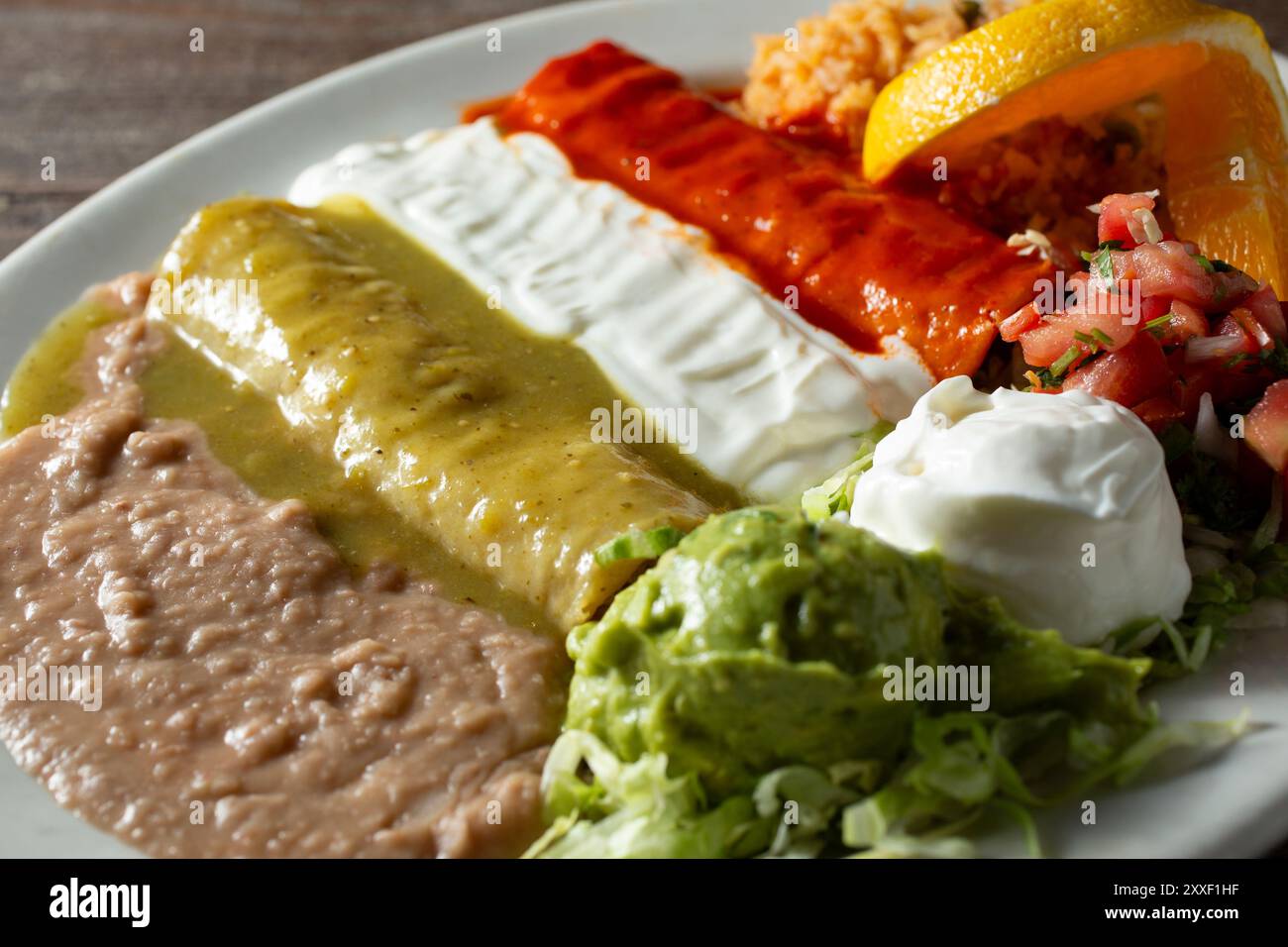 A view of three enchiladas covered in sauces, representing the Mexican flag colors. Stock Photo