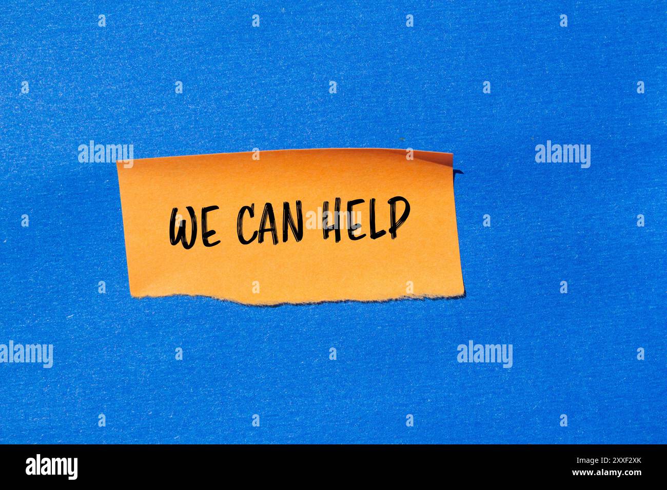 We can help message written on ripped torn orange paper piece with blue ...