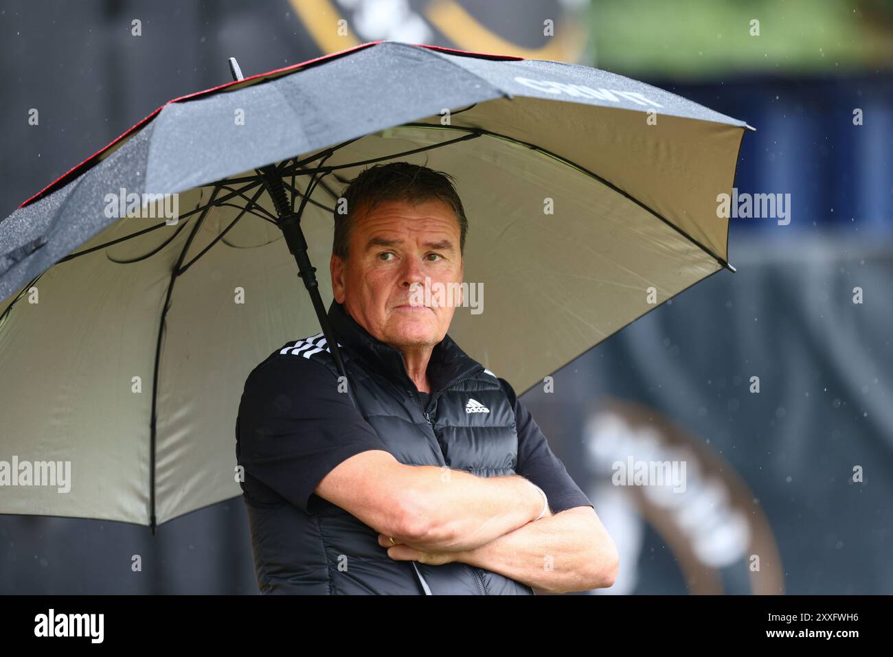 The Ledger Stadium, Bedford, UK, 24th Aug 2024, Supporter in the rain during Pitching In Southern League, Central Division One match between Real Bedford FC and North Leigh  FC held at Bedfords Ledger Stadium Credit: Nick Phipps/PhippsImages Credit: Nicholas Phipps/Alamy Live News Stock Photo