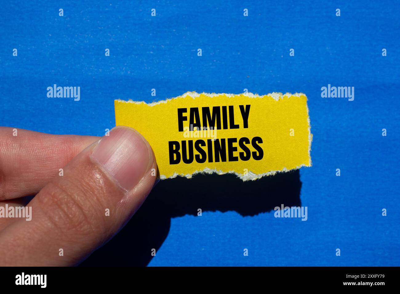 Family business message written on ripped torn yellow paper with blue ...