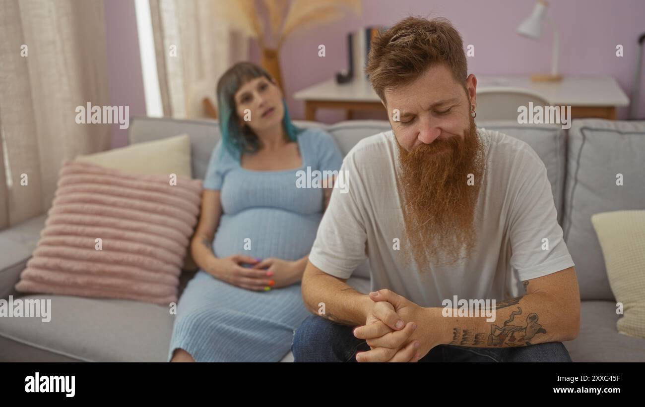 Pregnant woman and bearded man sitting together in a cozy living room ...