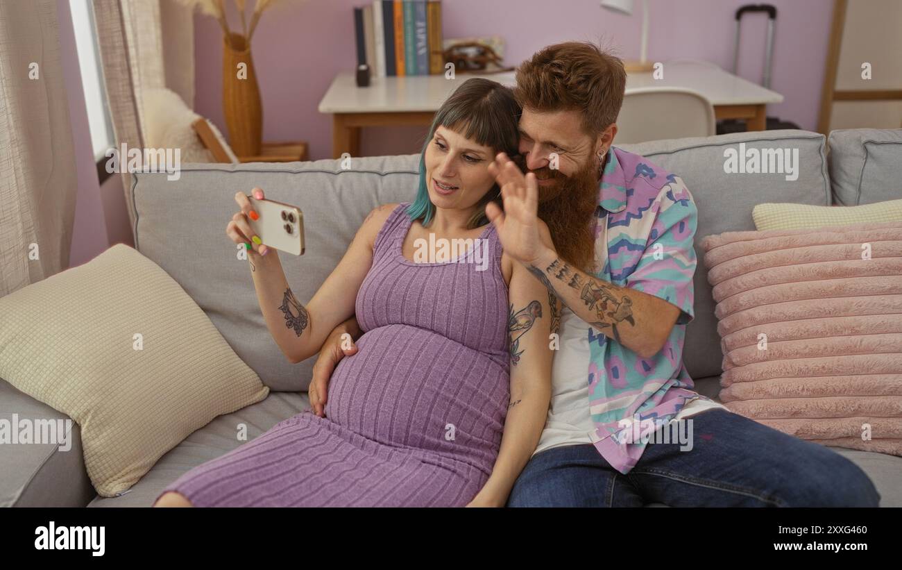 Pregnant woman and bearded man having a video call in cozy living room ...
