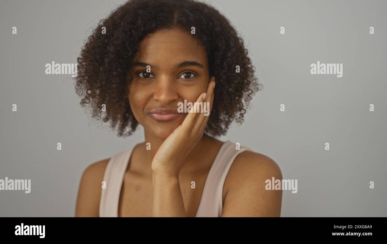 A beautiful young african american woman with curly hair poses against ...