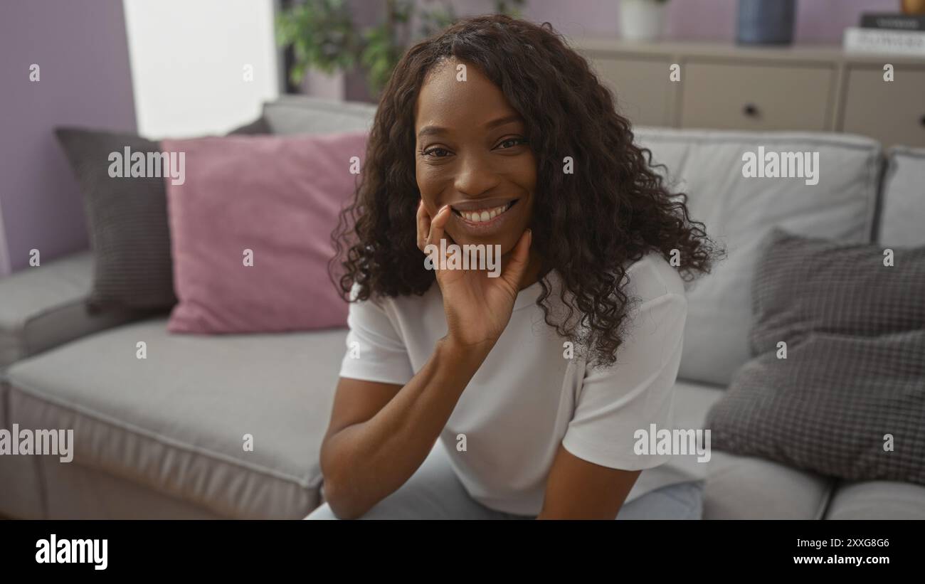 A beautiful young african american woman with curly hair smiles warmly ...