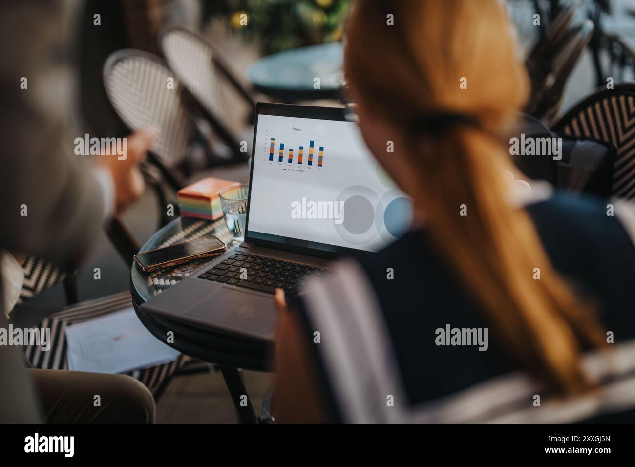 Business professionals analyzing charts and data on a laptop screen in ...