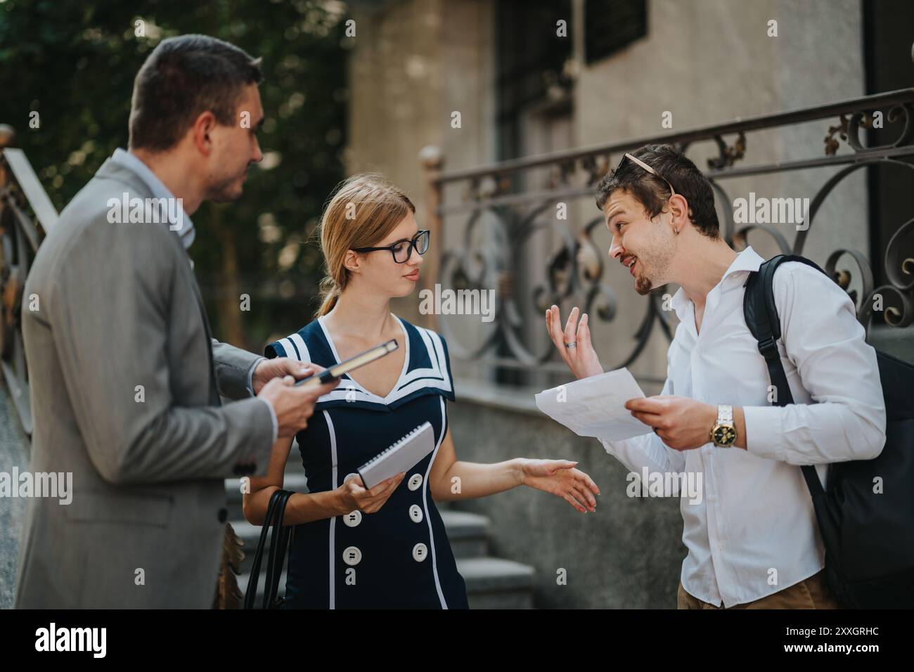 Business colleagues discussing project outside office building Stock ...