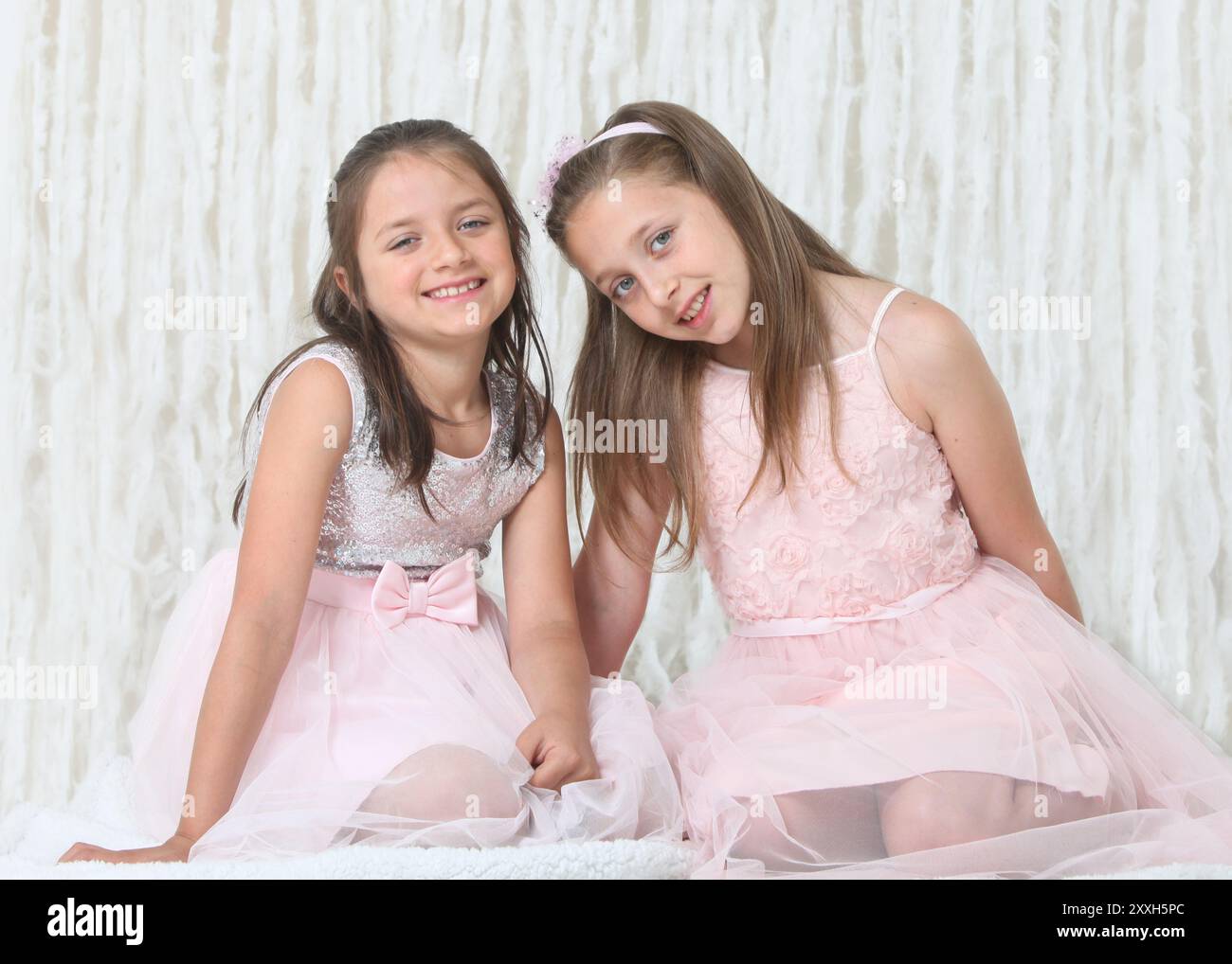 portrait of two pretty cheerful preteen girls in elegant dresses on ...