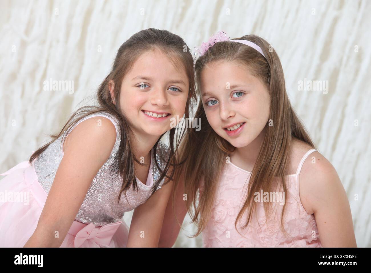 portrait of two pretty cheerful preteen girls in elegant dresses on ...